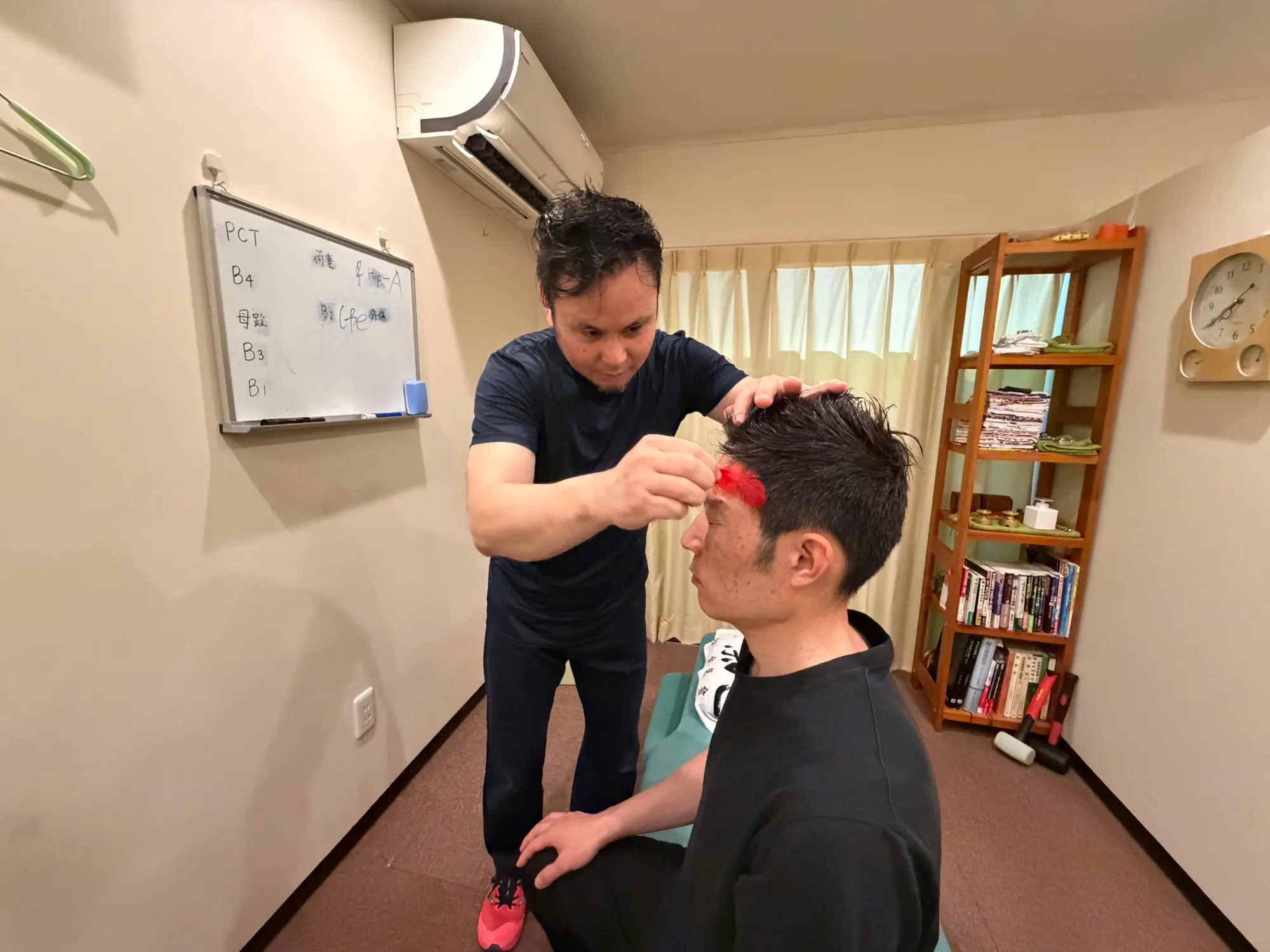 羽を使った検査の様子。額や腕の皮膚を撫でて頸椎のズレを特定